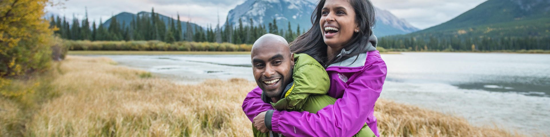 A millennial couple having fun along the shores of Vermillion Lakes with Mount Rundle in the background. Banff National Park.