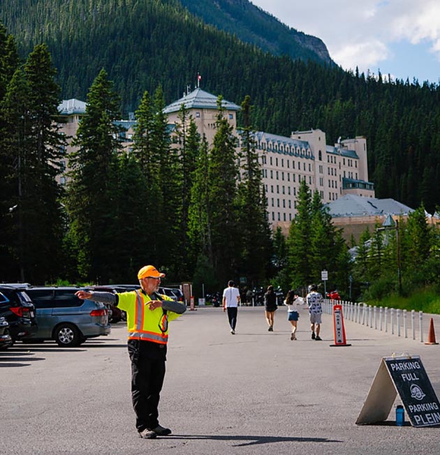 A person directing traffic in the Lake Louise parking lot.
