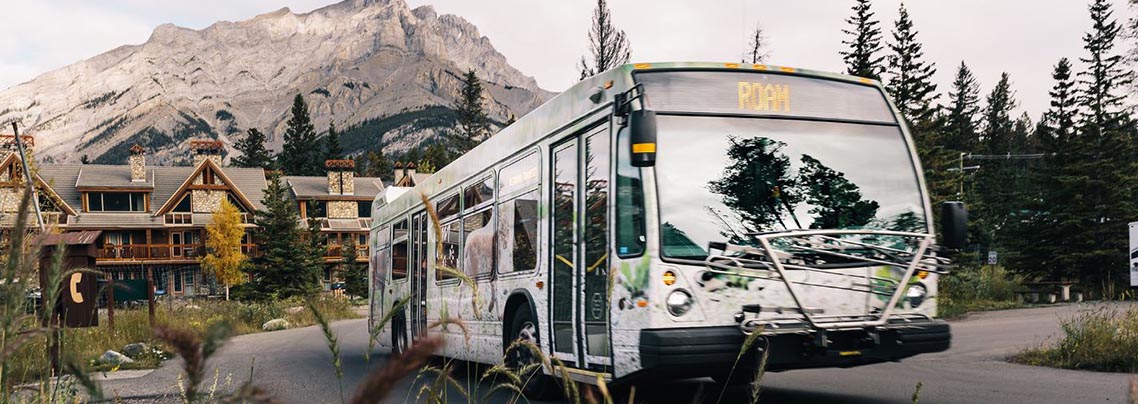 A Roam transit bus in front of a mountain in Banff