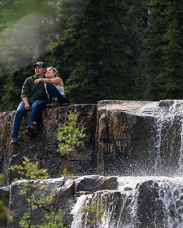 Couple assis sur des rochers, admirant la vue