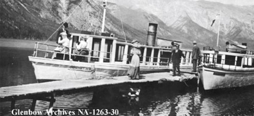 historic image of boat on lake minnewanka