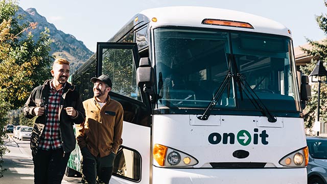 two people stepping off a bus
