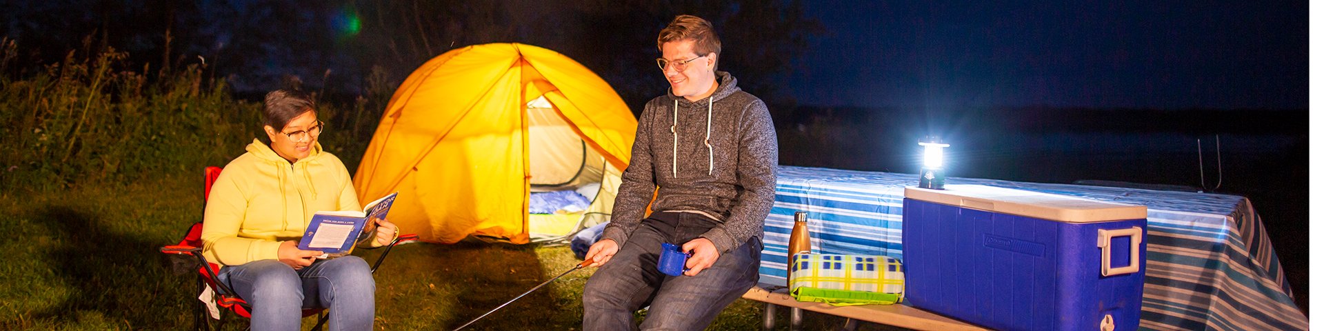 Un couple fait un feu de camp pendant la soirée au camping de l’arrière-pays du lac Oster, dans le parc national Elk Island.