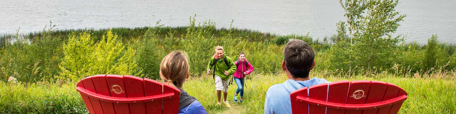 Visitors enjoy the view from the red chairs at the Bison Loop, Elk Island National Park.