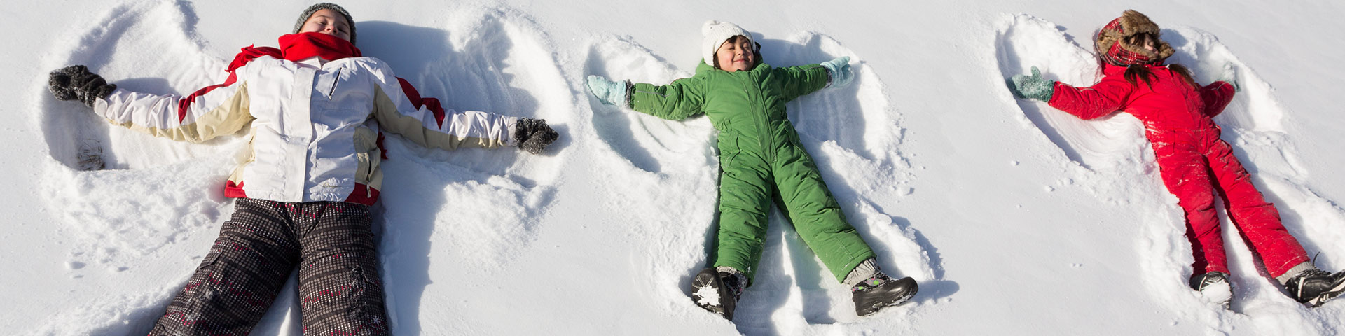 Children make snow angles in the snow in Elk Island National Park.