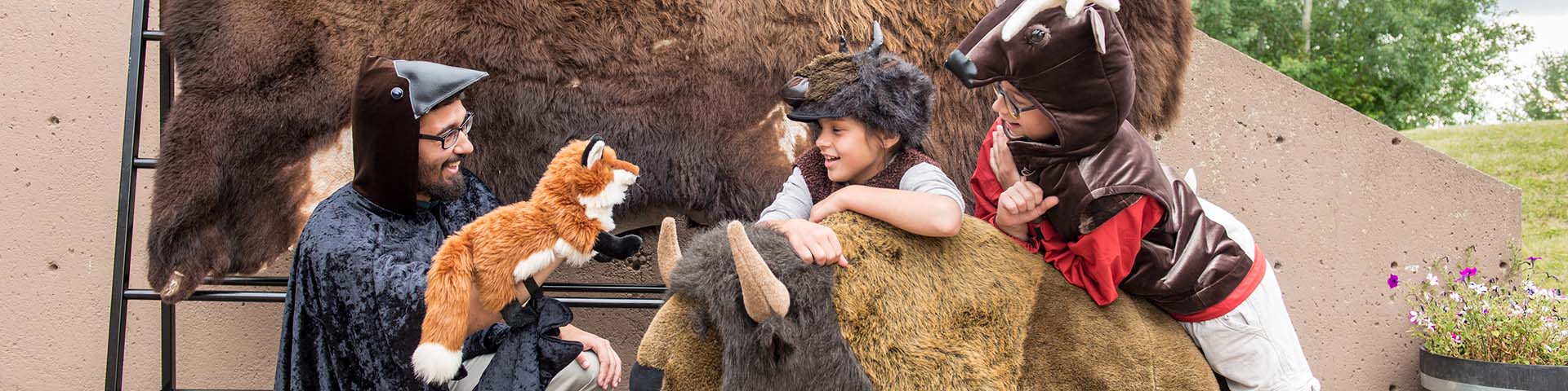 Un interprète costumé parle à des enfants déguisés en animal devant le théâtre Astotin, parc national Elk Island. 