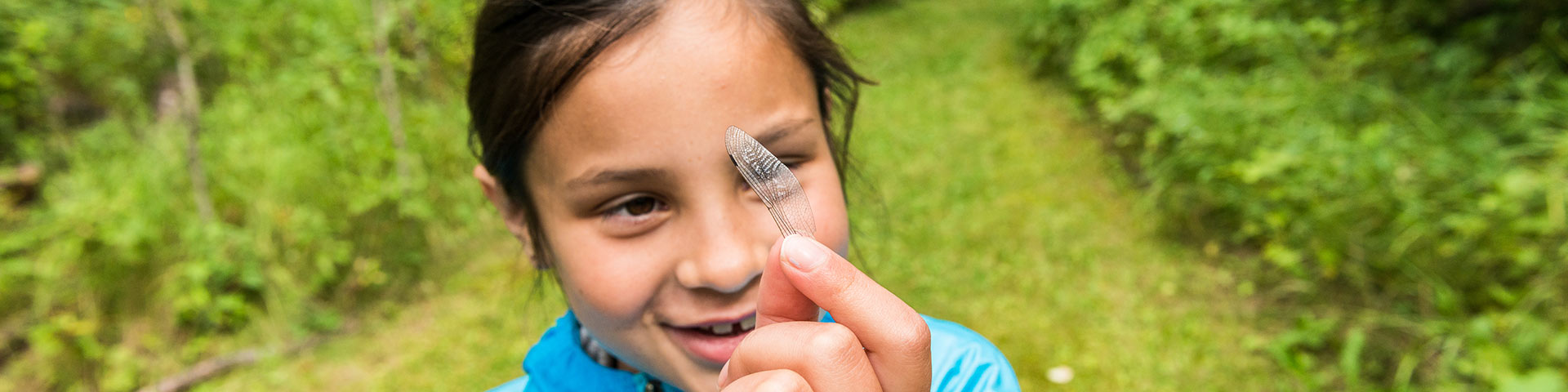 A young visitor investigates a dragonfly wing, Elk Island National Park.