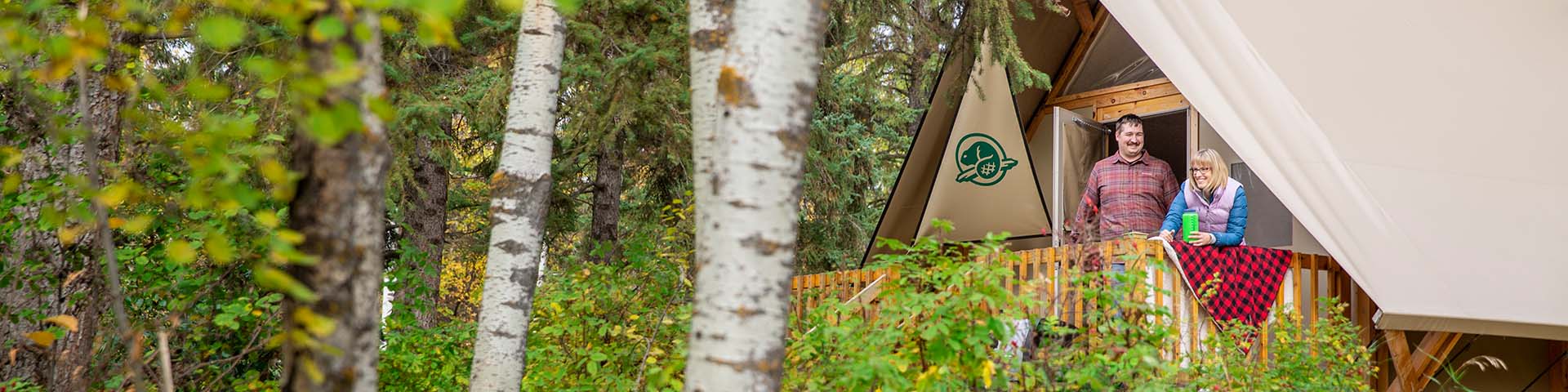 Un couple regarde le paysage depuis leur tente oTENTik au camping du lac Astotin, dans le parc national Elk Island. 