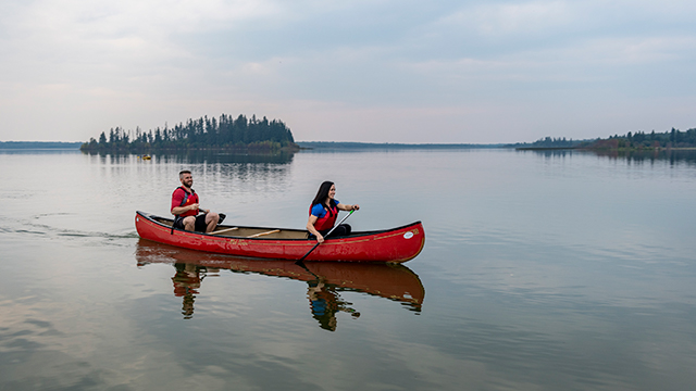 Canoers paddle on Astotin Lake, Elk Island National Park. Elk Island National Park