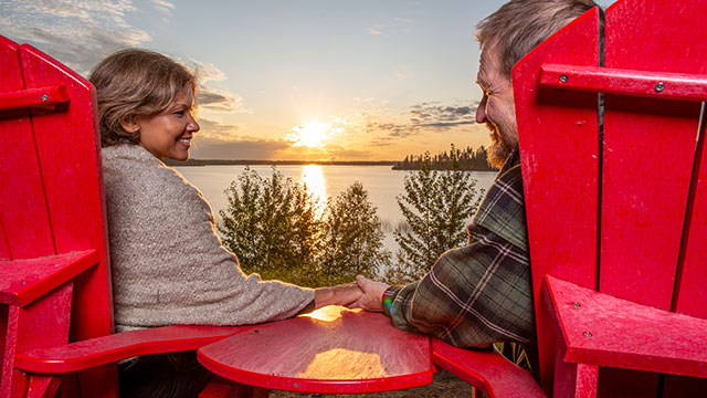 Visitors enjoy the view from the red chairs at the Bison Loop, Elk Island National Park.