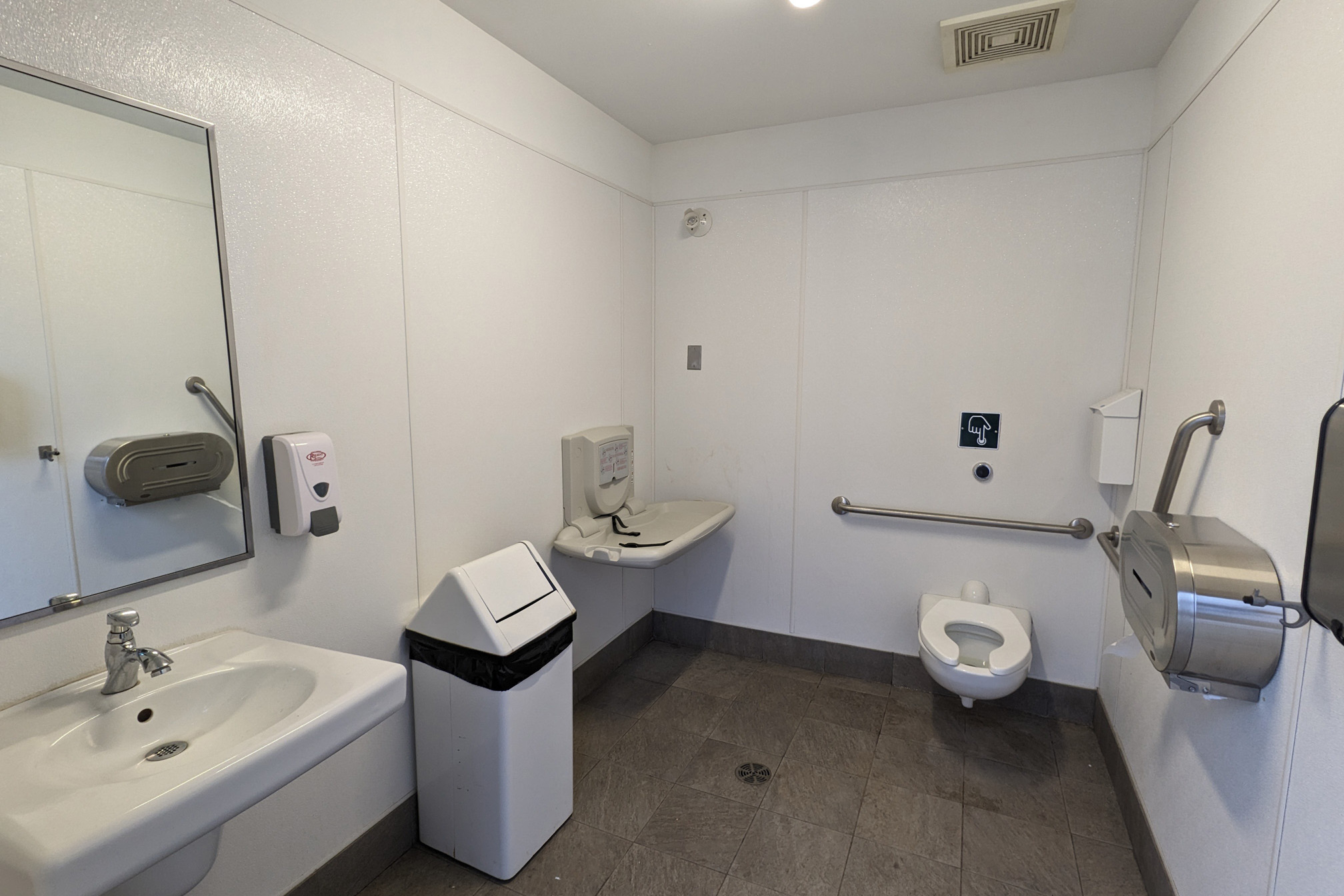Intérieur de l’une des toilettes au Centre d’information aux visiteurs. Deux des six toilettes ont des tables à langer, lesquelles sont indiquées par des symboles sur les portes.