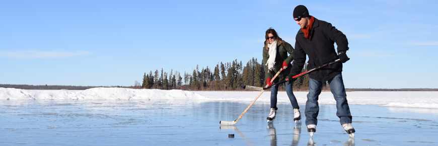 A couple plays hockey on the Astotin Lake skating rink.
