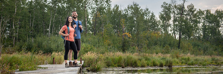 A couple spots a beaver lodge along Amisk Wuche Trail. 