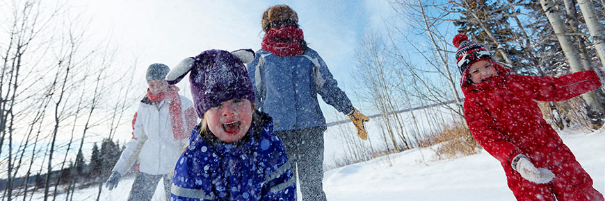 A family plays in the snow in the Astotin Lake Area. 