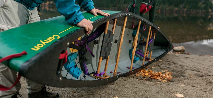 Close-up of a canoe lying on its side on the shore, being prepared for cleaning.