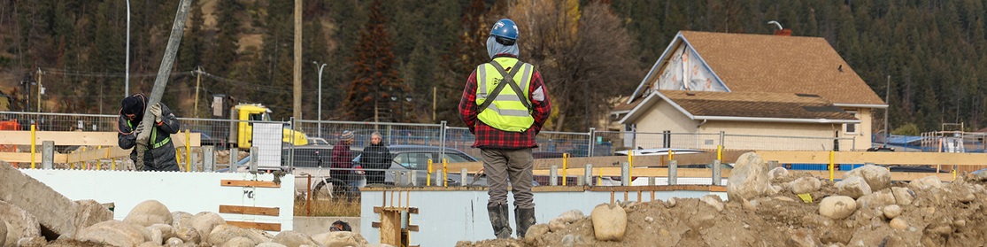 Back of a construction worker overlooking a construction site.