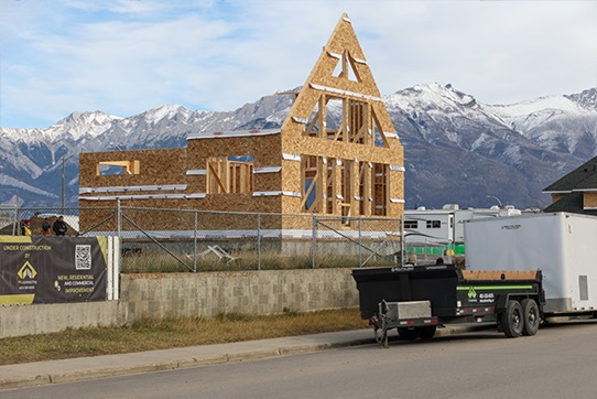 House under construction with protective barriers around the site.