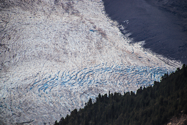 Bird's-eye view of a glacier with visible cracks and breaks (crevasses).