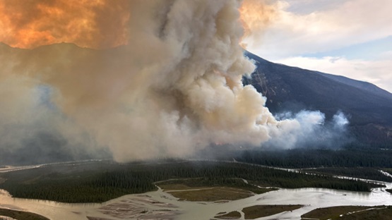 A river with a fiery smoke overhead.
