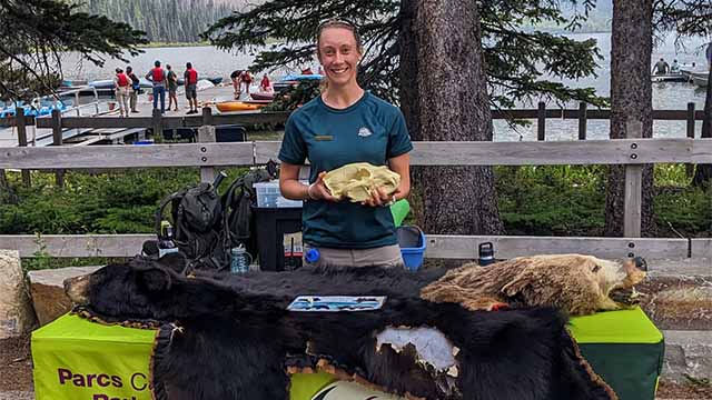 Parks Canada Interpreter with a table displaying bear pelts