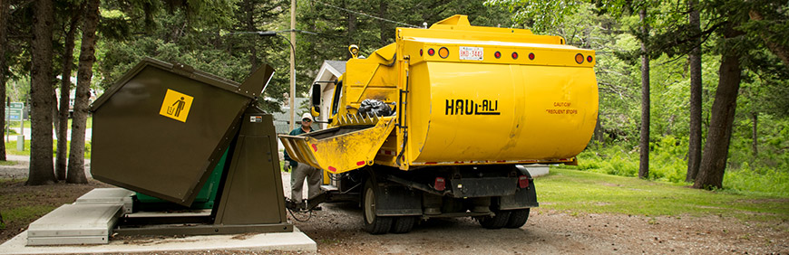 Garbage truck collecting waste from Parks Canada dumpster