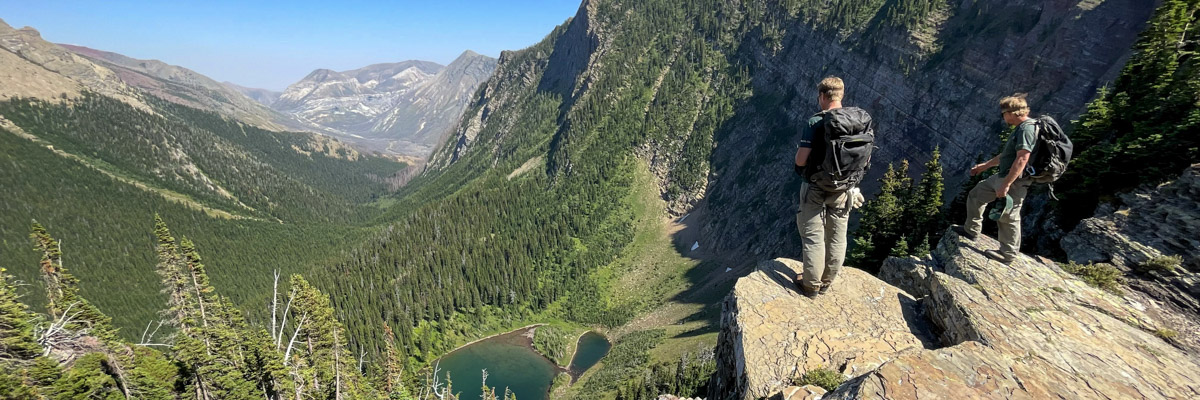 Parks Canada staff overlooking a valley from a rocky outcrop