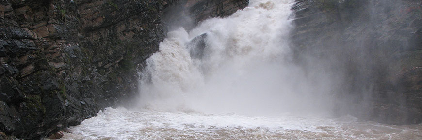 Water gushes down a waterfall during a flood