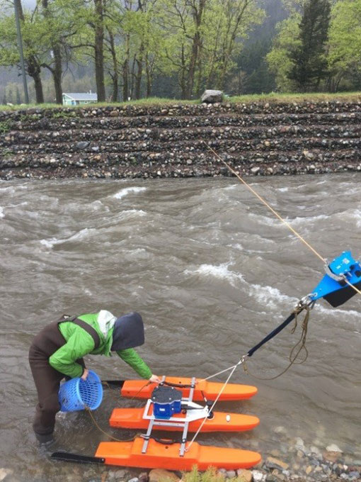 A scientist works with testing equipment in a stream