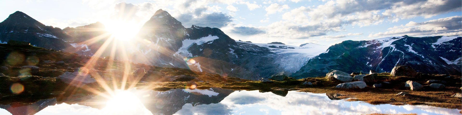 Lever du soleil sur un lac alpin avec un décor montagneux et glaciaire