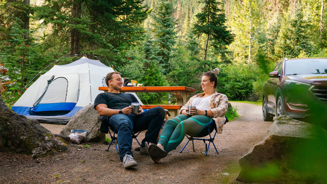 two campers relaxing in camp chairs