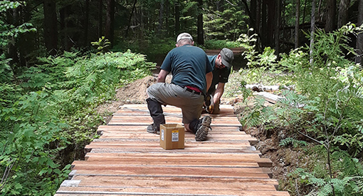 Two Parks Canada employees working on a boardwalk