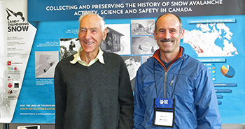 Peter Schaerer and Parks Canada Avalanche Officer, Jeff Goodrich at Land of Thundering Snow exhibit, 2014 © Revelstoke Museum and Archives Peter Schaerer and Jeff Goodrich stand in front of “Land of Thudering Snow” exhibit.