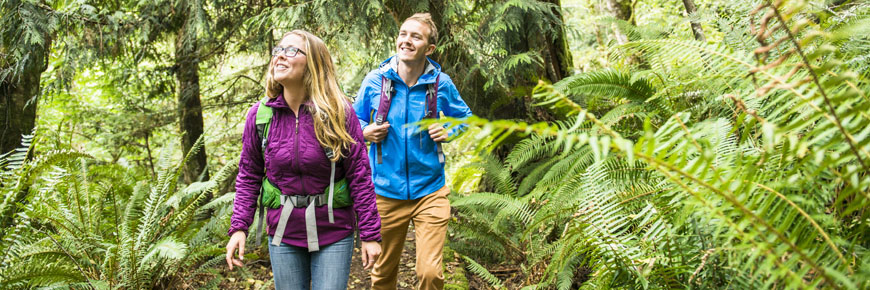 Two hikers enjoy the lush forest of the Lyall Creek trail, at the heart of Saturna Island. Gulf Islands National Park Reserve.