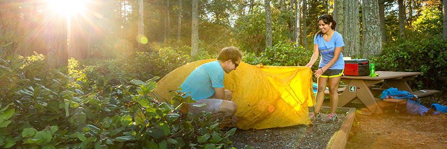  Un jeune couple monte sa tente sur le camping de l'Île D'Arcy.