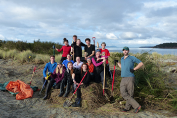 Volunteer university group poses with shovels in their hands on Sidney Island