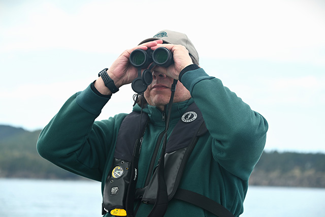 A person looks through binoculars.