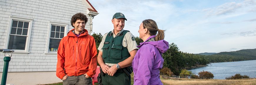 Gardien de parc national discutant avec deux visiteurs.