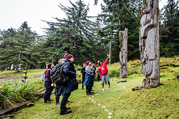 Visitors guided by a watchmen at SGang Gwaay