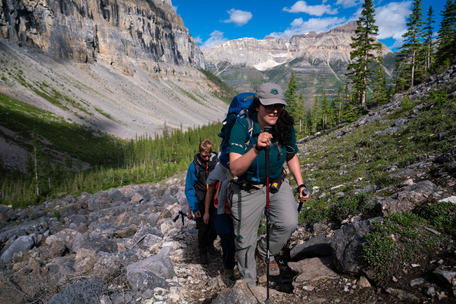 A Parks Canada guide hikes up the trail with a group.