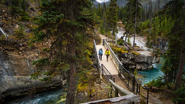 Two hikers on a bridge crossing Marble Canyon