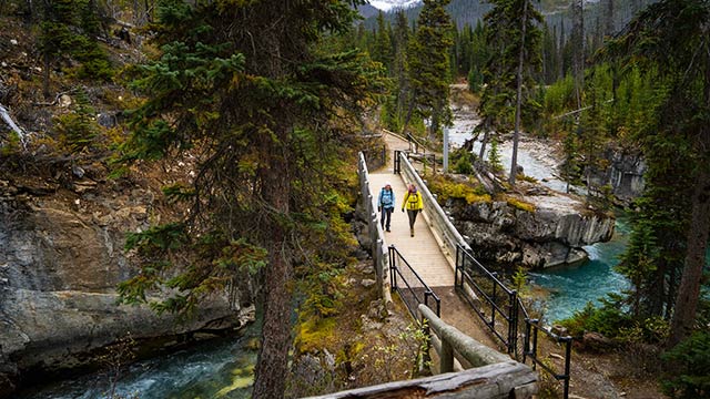 Two hikers on a bridge crossing Marble Canyon