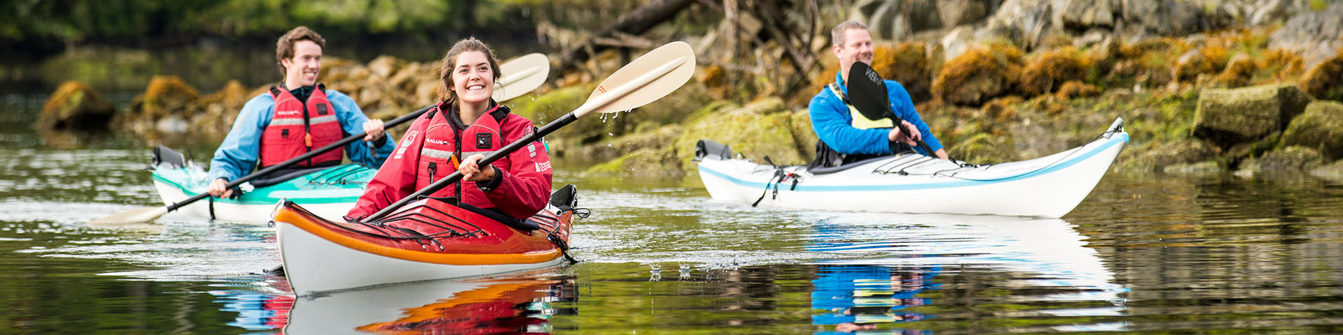 	Ces kayakistes admirent la végétation luxuriante qui recouvre la rive. Réserve de parc national Pacific Rim.