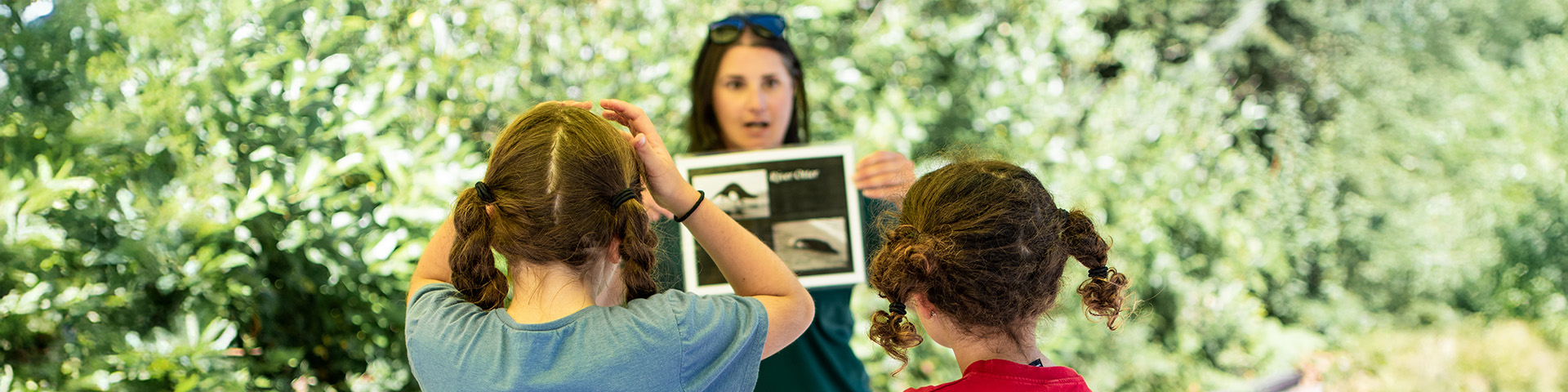 Interpreter holds up a photo in front of two children