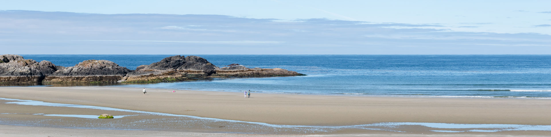 Beau paysage de plage avec des gens marchant au loin.