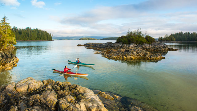 Two people paddling their kayaks in the Broken Group Islands