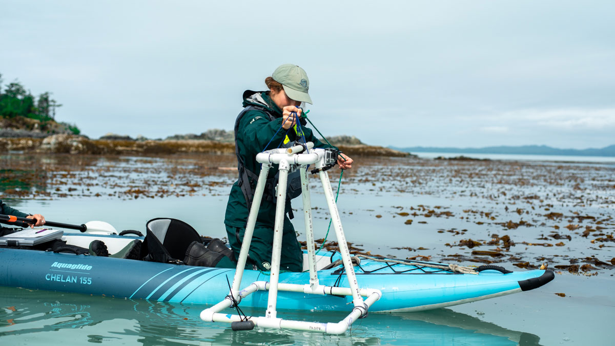 a person in a kayak looking through a monitoring device