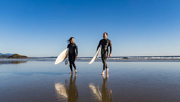 La silhouette de deux personnes se profile au coucher du soleil sur la plage 