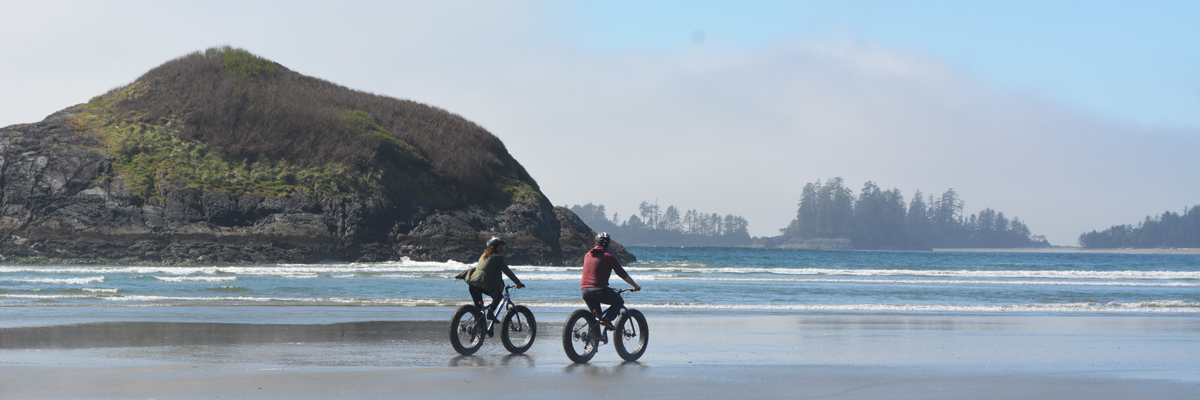 two people cycling on beach