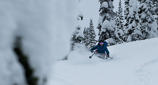 a skiers making a deep turn in fresh snow