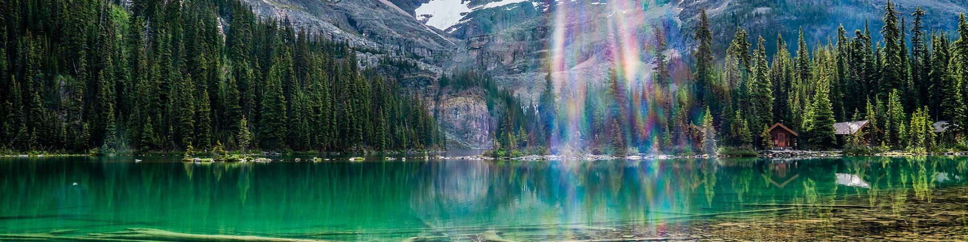 A sunbeam shines over the still water of Lake O’Hara